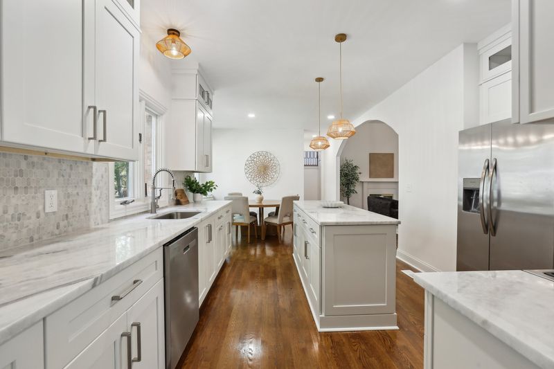 Abbottsford kitchen after renovation — bright white with marble countertops and modern pendants