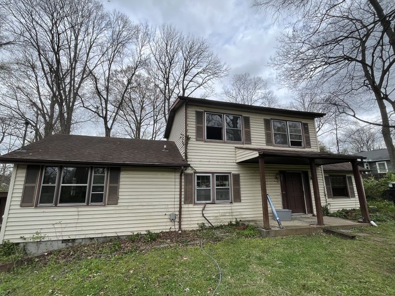 Log Cabin Rd exterior before — tired two-story with worn siding